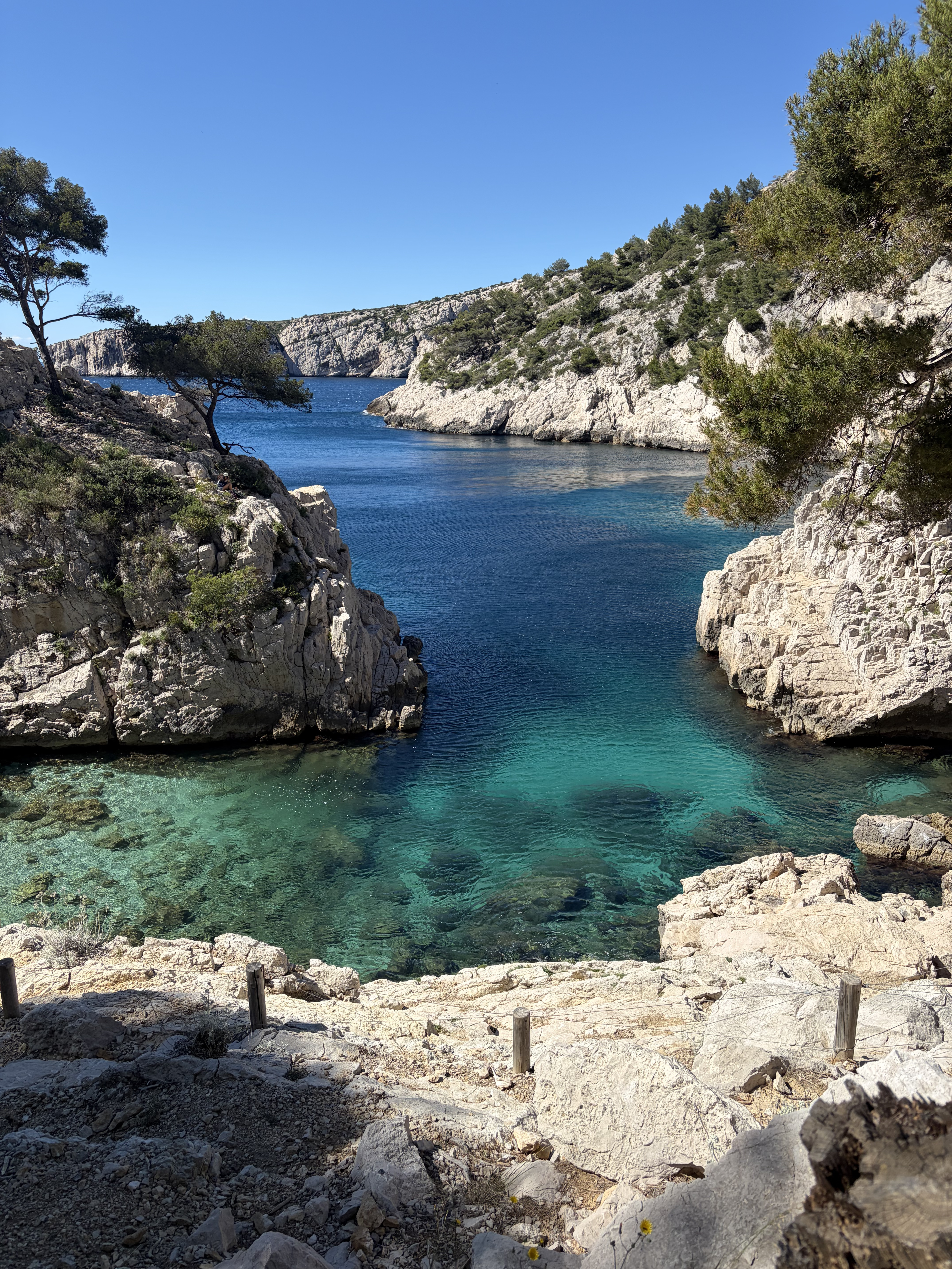 Calanque mediterránea de aguas turquesas entre acantilados de roca blanca